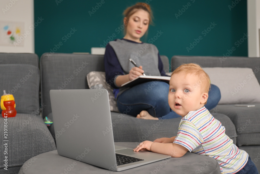 Cute little baby with laptop with mother at home Cute little baby with laptop with mother at home