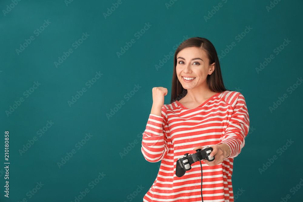 Young woman with gamepad on color background Young woman with gamepad on color background