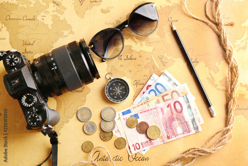 Photo camera, compass, sunglasses and money on world map. Travel planning concept Photo camera, compass, sunglasses and money on world map. Travel planning concept