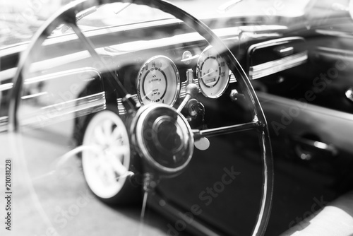 Vintage retro car interior, steering wheel, dashboard, black and white photo