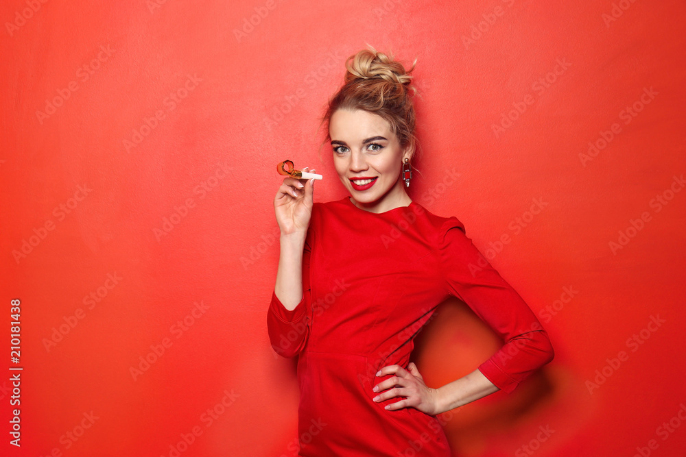 Portrait of beautiful young woman with party whistle on color background Portrait of beautiful young woman with party whistle on color background