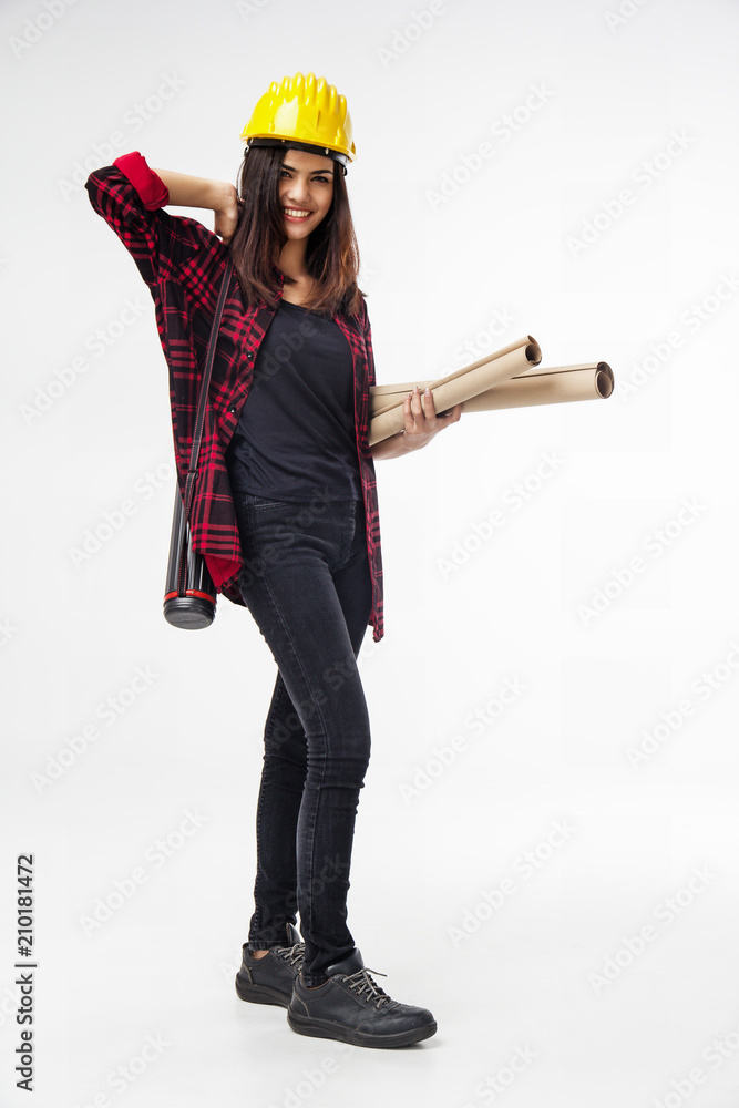 The young woman engineer with yellow safety helmet and hold blueprint in her hand,with smile and happy face The young woman engineer with yellow safety helmet and hold blueprint in her hand,with smile and happy face