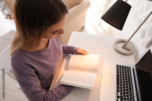 Young woman reading book at...