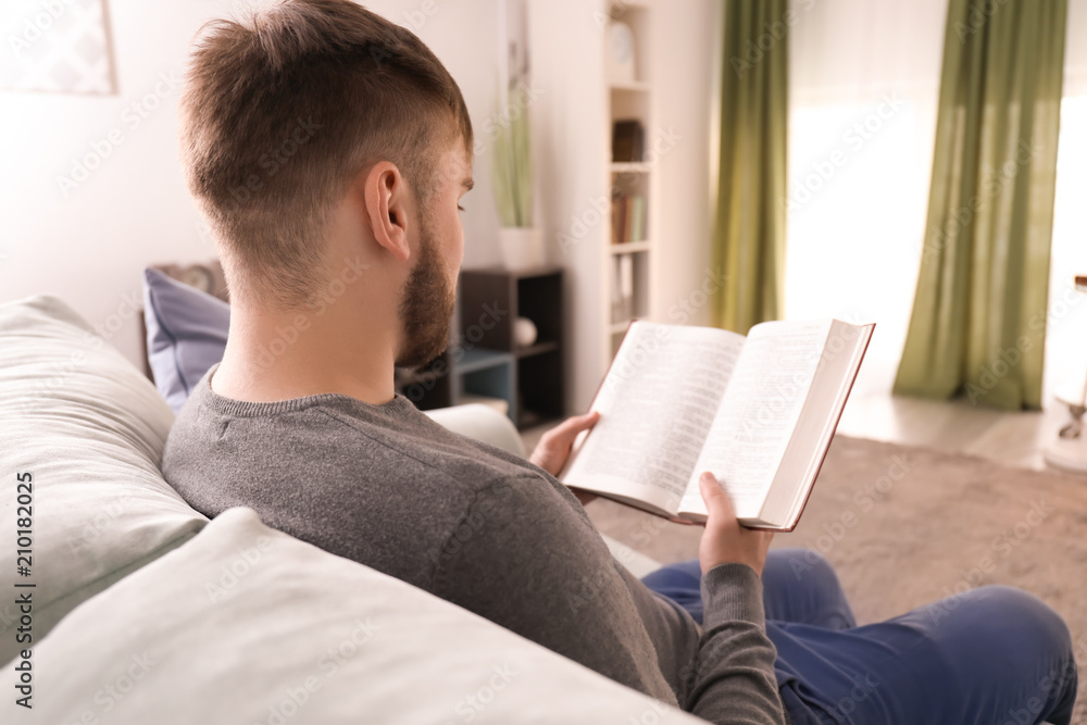 Young man reading book at home Young man reading book at home
