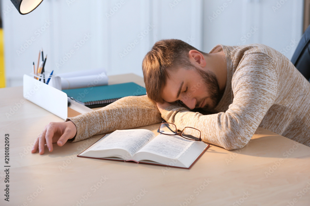 Definitive trolley bus alignment Tired young man sleeping at table with book Stock Photo | Adobe Stock