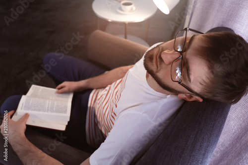 Young man with book sleepin...
