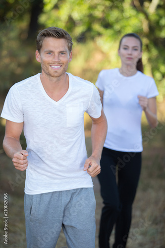 beautiful young couple running together in the park