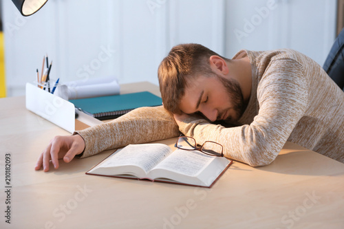 Tired young man sleeping at...