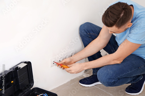 Electrician repairing sockets indoors