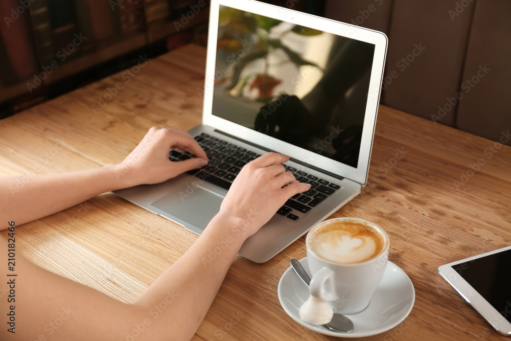 Fototapeta premium Young freelancer with laptop working in cafe