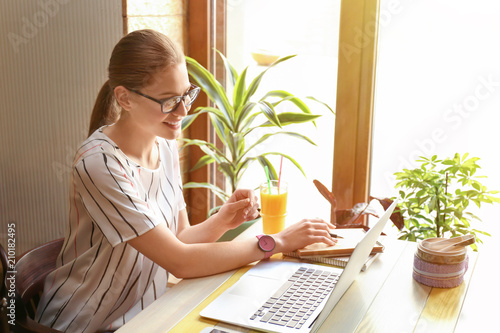 Young freelancer with laptop working in cafe