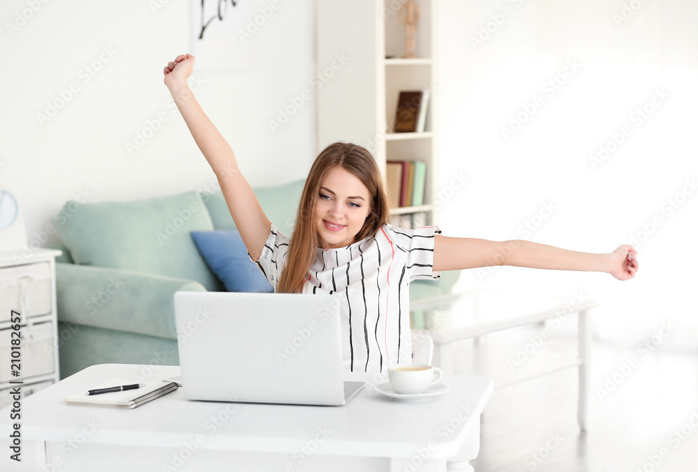 Happy female freelancer working on laptop in home office Happy female freelancer working on laptop in home office