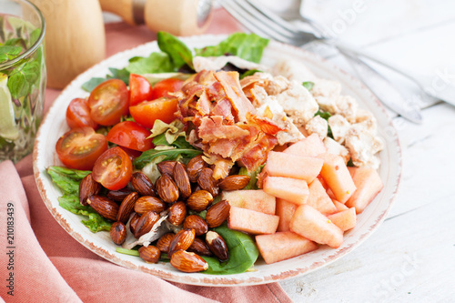 Salad with apple, bacon, cashew cheese, tomatoes, almonds