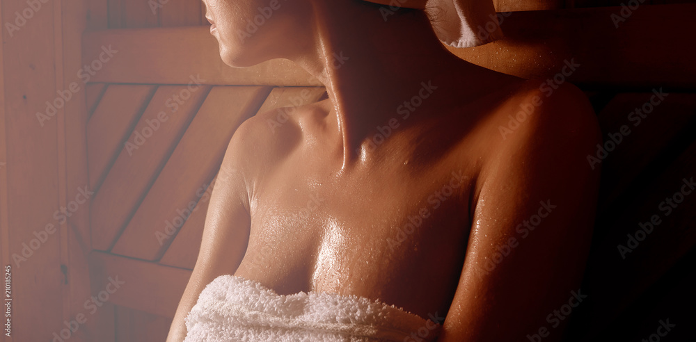 girl in a spa treatment in a traditional sauna with a brush for skin and a  washcloth. relaxes wrapped in a white towel Stock-Foto | Adobe Stock