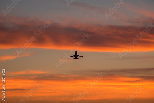 Silhouetted commercial airline over sunset sky © Nicholas Steven