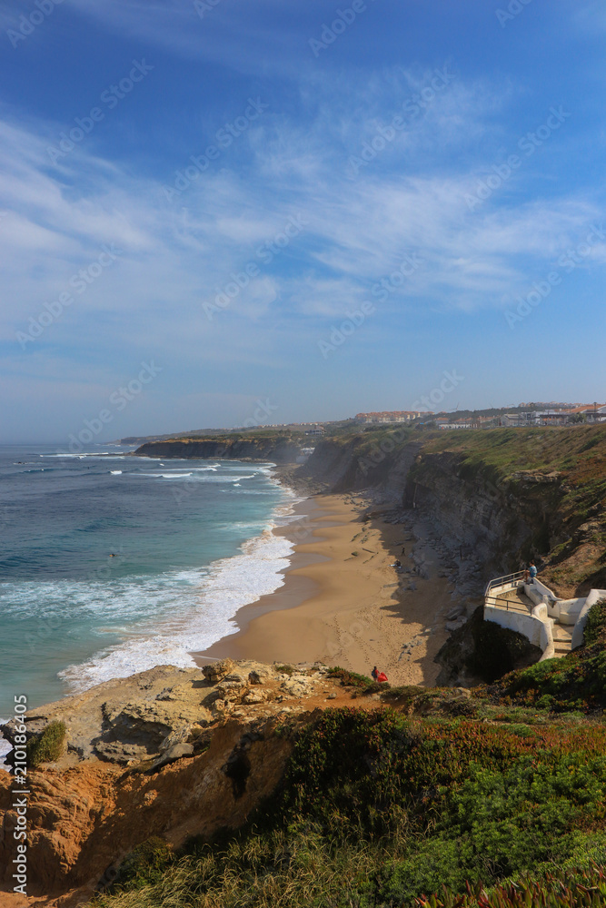 Amazing sandy beach in a summer day, with blue waves. Surf spot in Ericeira Portugal