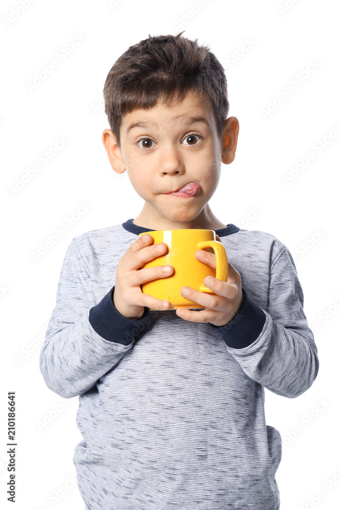 Cute little boy with cup of hot cocoa drink on white background