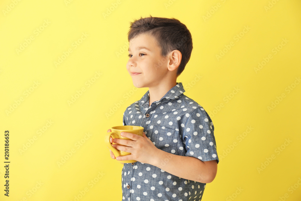 Cute little boy with cup of hot cocoa drink on color background Cute little boy with cup of hot cocoa drink on color background
