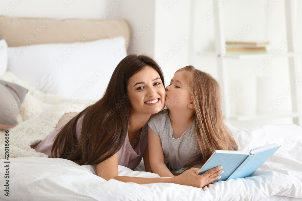 Mother and her daughter reading book together at home Mother and her daughter reading book together at home