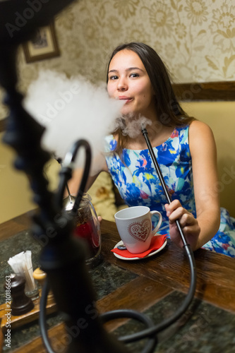 Girl in bright outfit smoking hookah photo