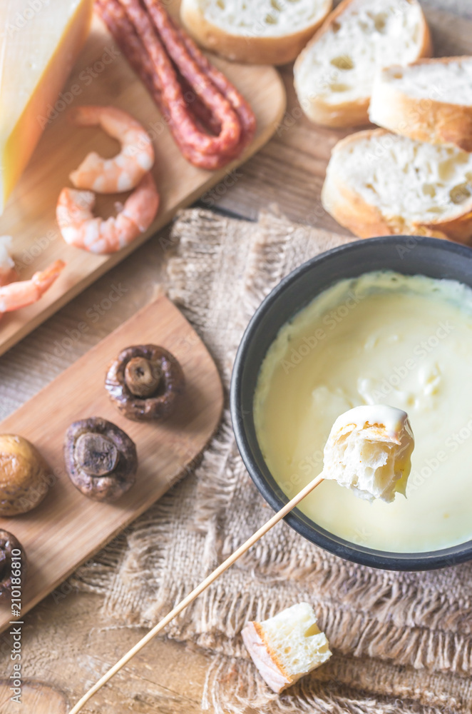 Bowl of fondue with appetizers Bowl of fondue with appetizers