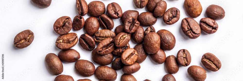 Panoramic background with roasted coffee beans in the middle on a white table Panoramic background with roasted coffee beans in the middle on a white table