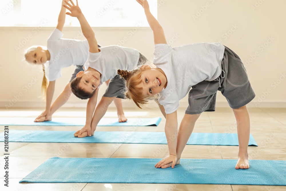 Little children practicing yoga indoors - obrazy, fototapety, plakaty 