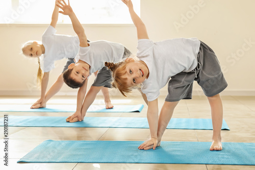 Fototapeta Naklejka Na Ścianę i Meble -  Little children practicing yoga indoors