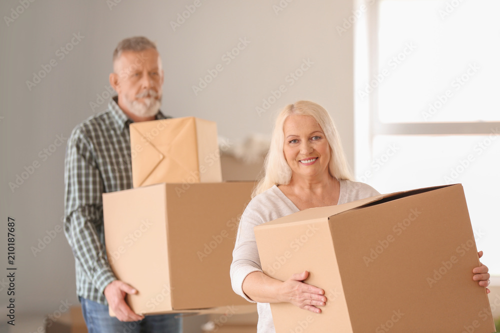 Mature couple with moving boxes at new home Mature couple with moving boxes at new home