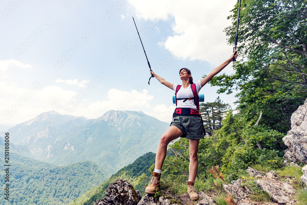 Female hiker with raised hands at top of mountain