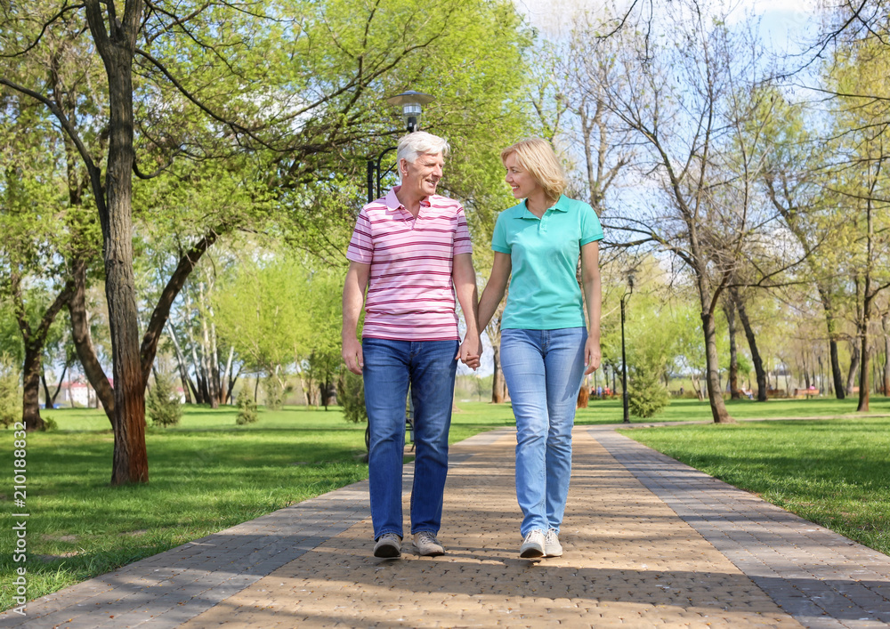 Mature couple walking in park on spring day