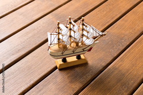 Model of an old sailing ship on wooden background. Travel concept