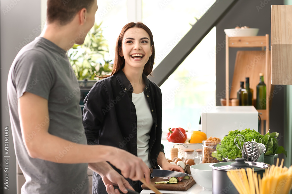 Young couple cooking together in kitchen Young couple cooking together in kitchen
