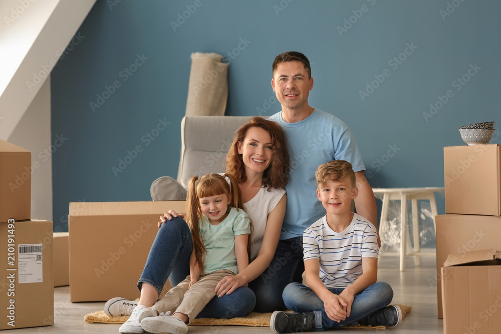 Happy family with cardboard boxes indoors. Moving into new house Happy family with cardboard boxes indoors. Moving into new house