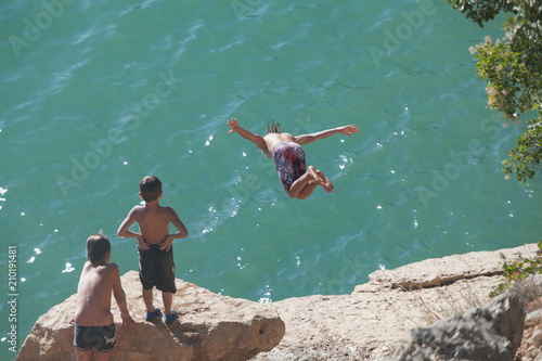 Teenage boy jumping from rock