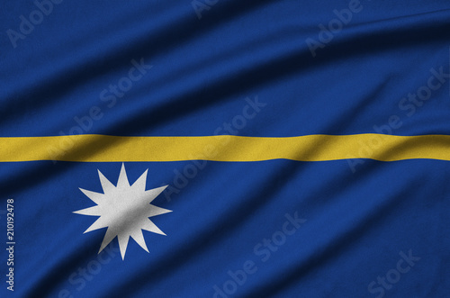 Nauru flag  is depicted on a sports cloth fabric with many folds. Sport team banner photo