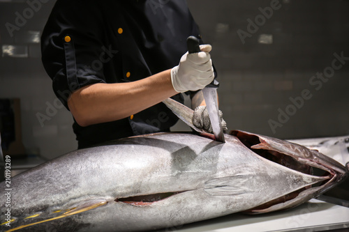 Bilde på lerret Man cutting fresh tuna on table in fish market