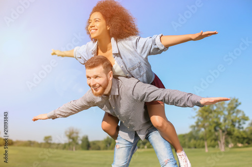 Young loving interracial couple having fun outdoors on spring day