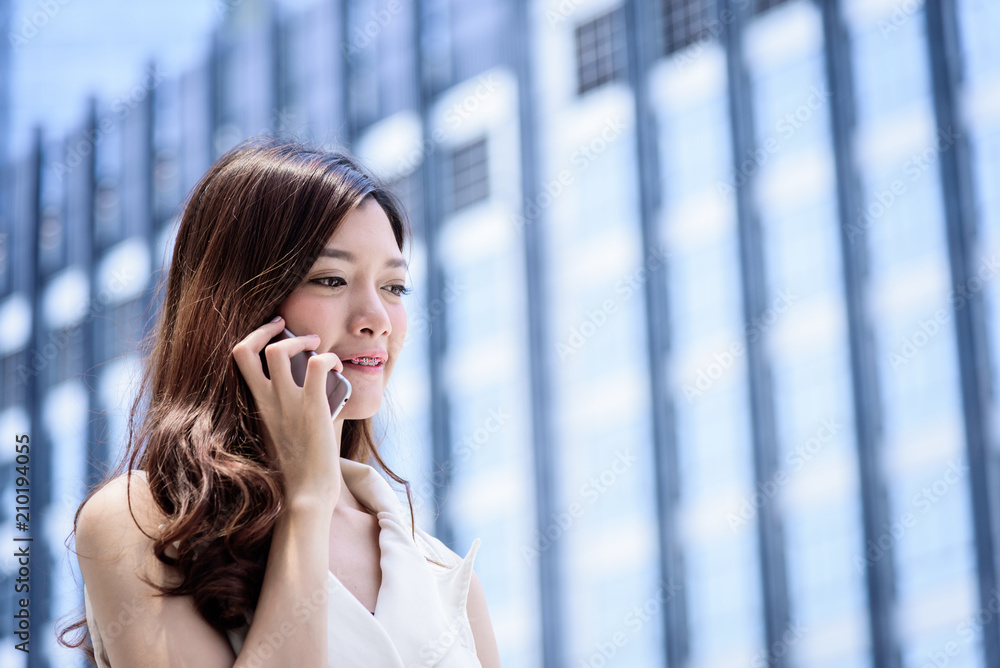 The asian business woman working and operation in outside office with building and city background. The asian business woman working and operation in outside office with building and city background.
