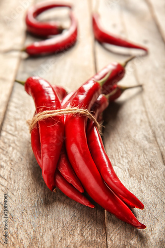Tied fresh chili peppers on wooden background