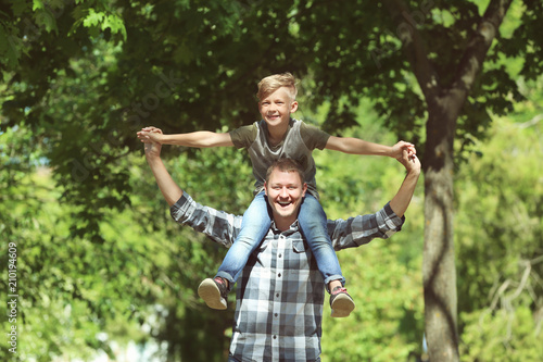 Happy father and son in park on sunny day