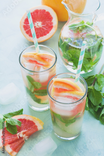Refreshment grapefruit cocktail with mint on mint color background. Healthy citrus summer drink. Toned