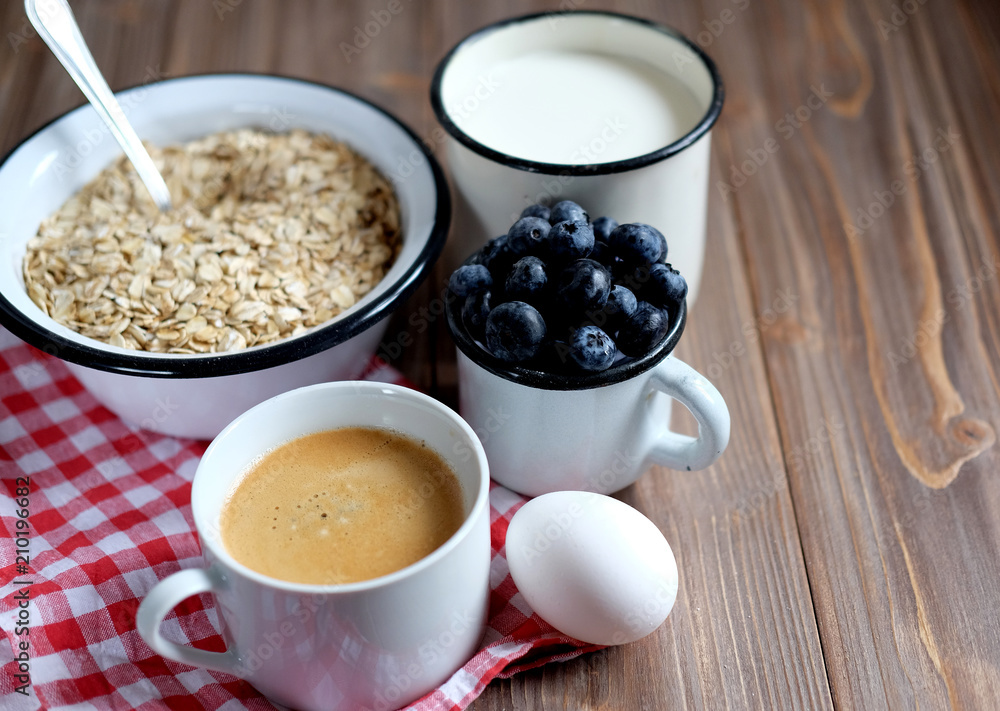 A healthy breakfast is a great start to a new day. Oatmeal porridge, coffee, berries and nuts on a wooden table. A healthy breakfast is a great start to a new day. Oatmeal porridge, coffee, berries and nuts on a wooden table.