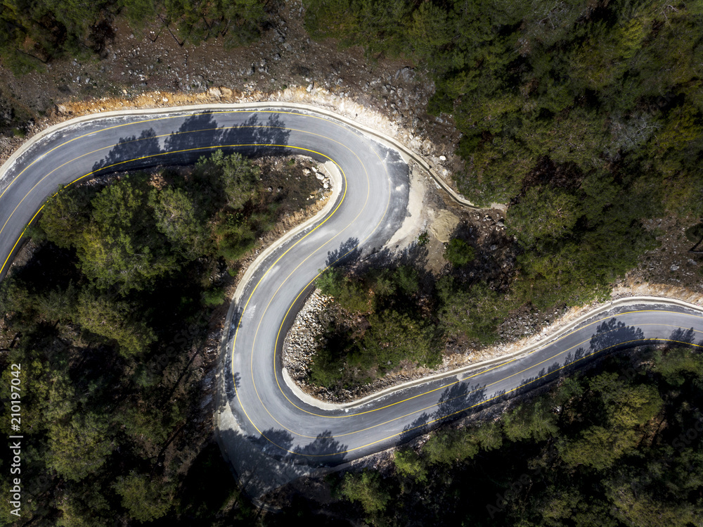 Aerial view of a winding mountain road surrounded in forest, Fethiye, Turkey