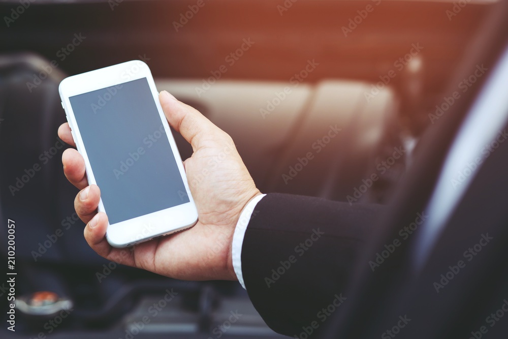 close up businessman hand using a mobile smart phone call a car mechanic ask for help assistance because car broken. close up businessman hand using a mobile smart phone call a car mechanic ask for help assistance because car broken.
