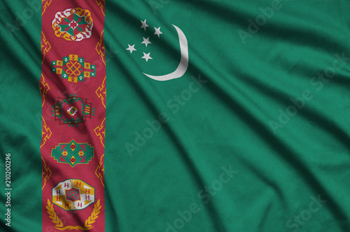 Turkmenistan flag  is depicted on a sports cloth fabric with many folds. Sport team banner photo