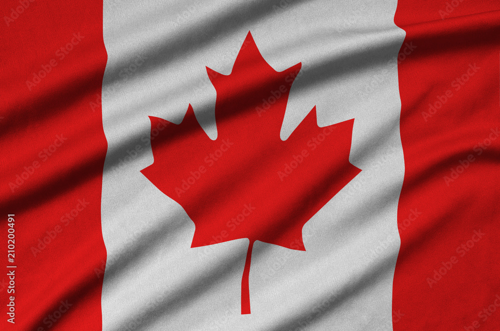 Fototapeta premium Canada flag is depicted on a sports cloth fabric with many folds. Sport team banner