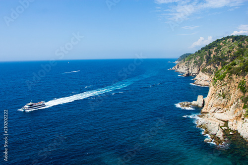 beautiful view of rocky cliff and yacht in blue sea in Spain