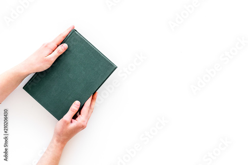 Reading for leasure. Hands take hardback book with empty cover on white background top view space for text