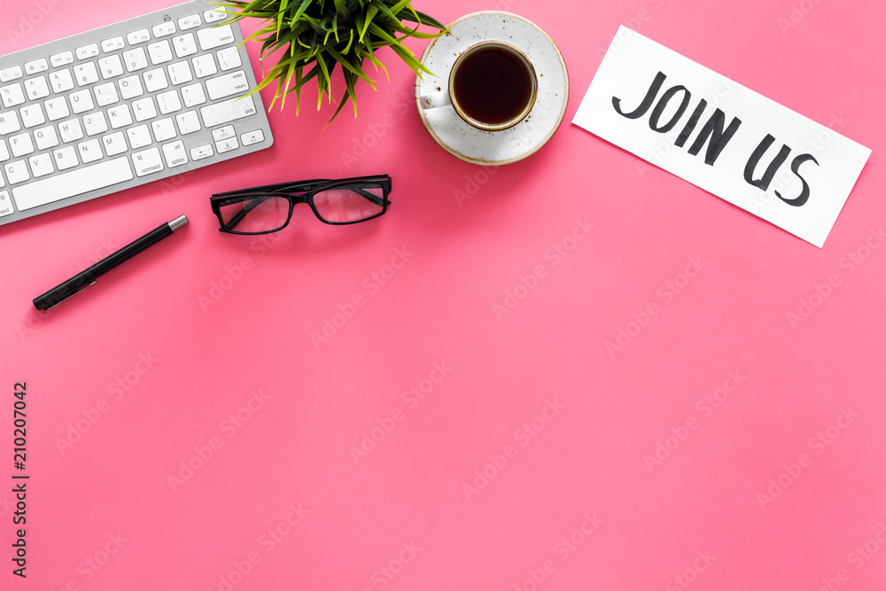 Template for contacts. Hand lettering Join us on work desk with glasses, coffe, plant, computer keyboard on pink background top view copy space Template for contacts. Hand lettering Join us on work desk with glasses, coffe, plant, computer keyboard on pink background top view copy space